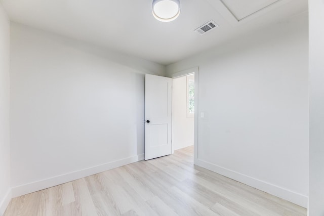 unfurnished room featuring light wood-type flooring, visible vents, and baseboards