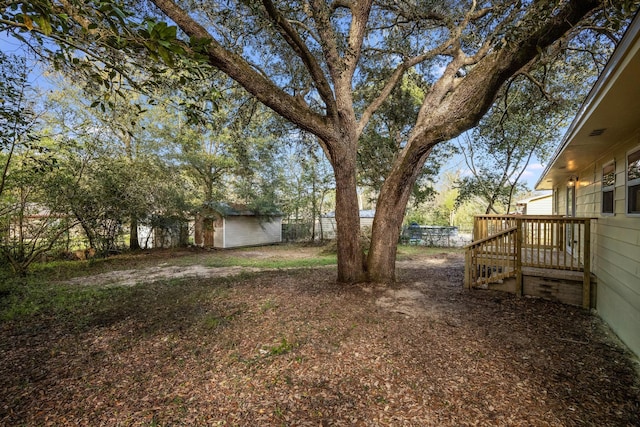 view of yard with an outbuilding, a shed, and fence