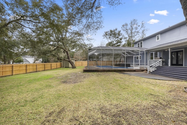 view of yard featuring a patio, a fenced backyard, french doors, a fenced in pool, and a lanai