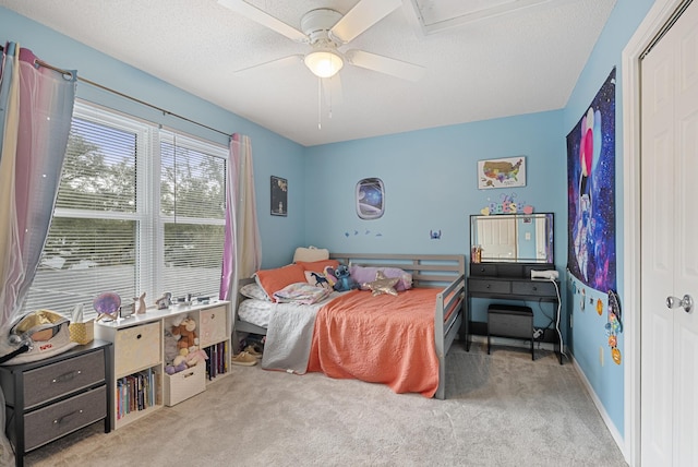 carpeted bedroom with a closet, baseboards, a textured ceiling, and ceiling fan