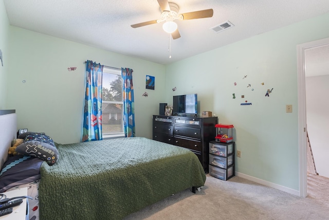 bedroom with visible vents, a textured ceiling, carpet, baseboards, and ceiling fan