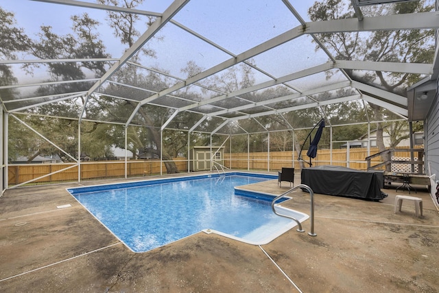 view of pool with an outbuilding, a storage shed, a fenced backyard, and a patio area