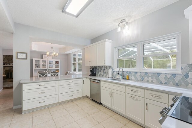 kitchen with range with electric cooktop, a sink, light countertops, stainless steel dishwasher, and tasteful backsplash