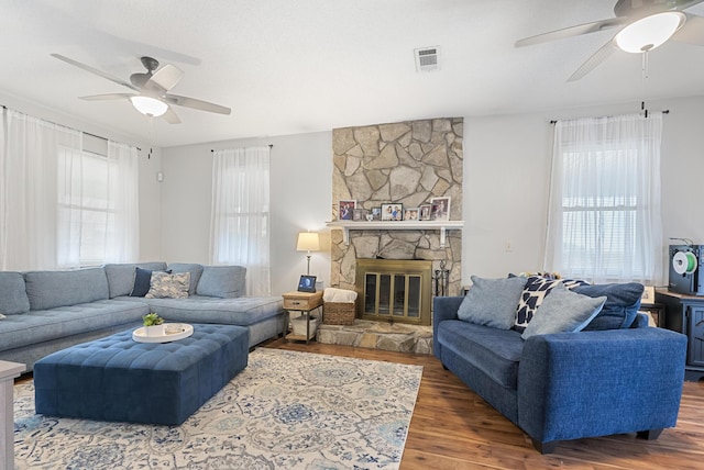 living area with visible vents, a healthy amount of sunlight, and wood finished floors