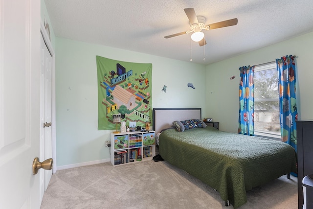 carpeted bedroom with ceiling fan, baseboards, a closet, and a textured ceiling