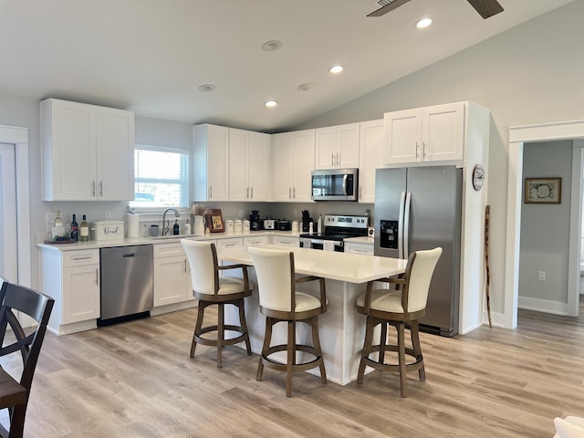 kitchen featuring stainless steel appliances, light countertops, a sink, and white cabinetry