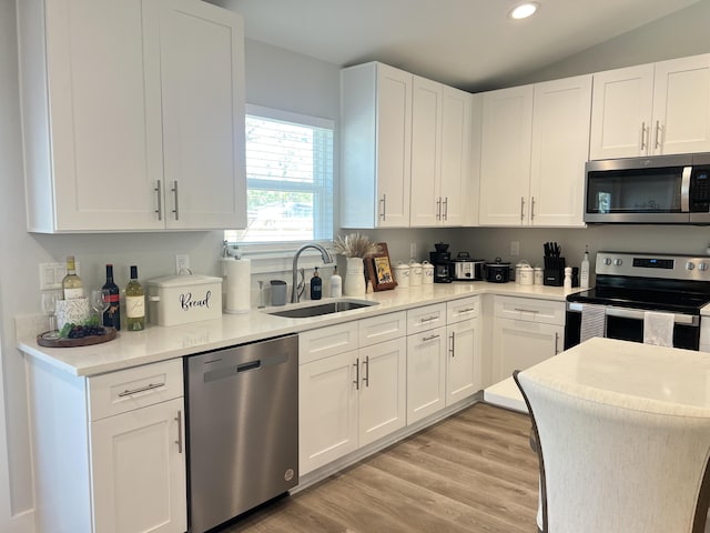 kitchen featuring white cabinets, stainless steel appliances, a sink, and recessed lighting