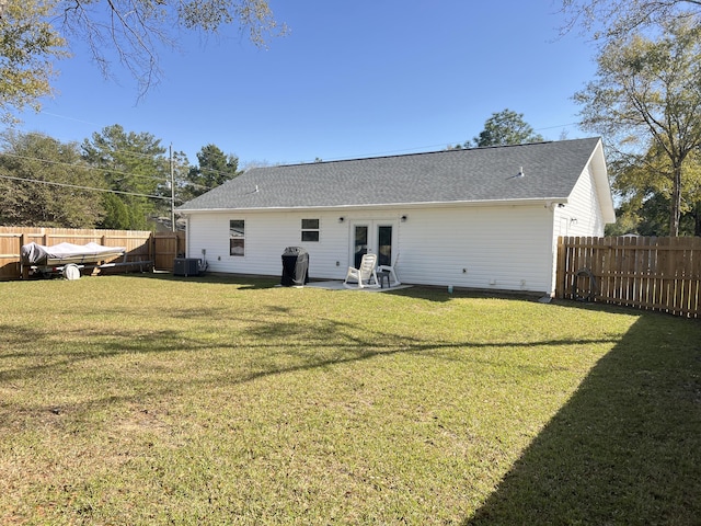 rear view of house featuring a lawn, a fenced backyard, cooling unit, french doors, and a patio area