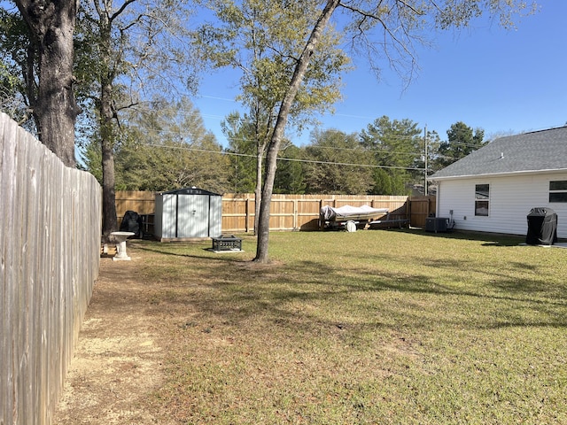 view of yard with central AC unit, a shed, a fenced backyard, an outdoor structure, and a fire pit