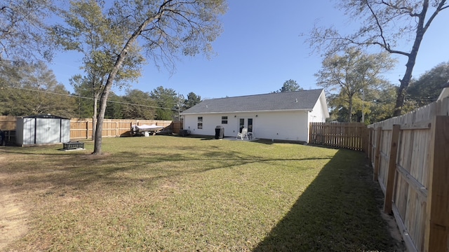 view of yard featuring a fenced backyard, an outdoor structure, and a storage shed