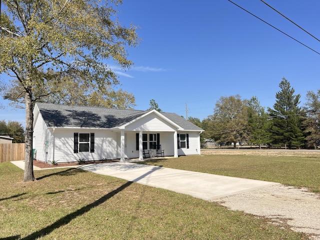 view of front facade featuring a porch, a shingled roof, fence, concrete driveway, and a front lawn