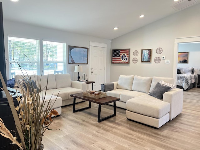 living area with light wood-style floors, recessed lighting, visible vents, and vaulted ceiling