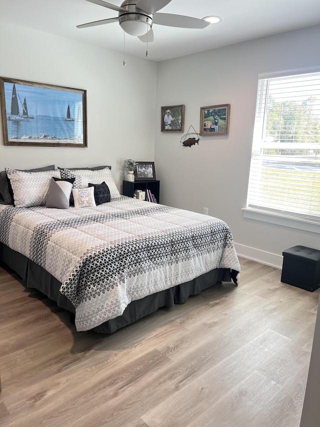 bedroom with ceiling fan, baseboards, and wood finished floors