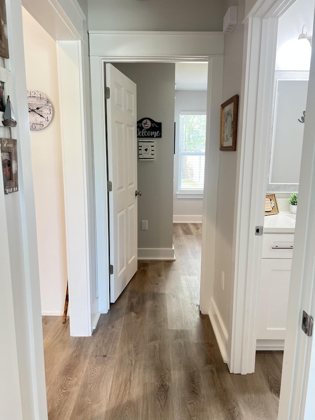 hall featuring baseboards and wood finished floors