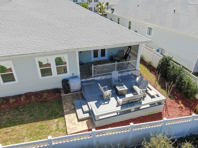 back of house with a fenced backyard, roof with shingles, and a wooden deck