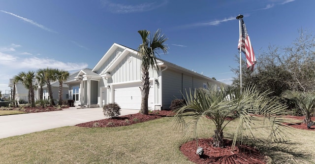 view of property exterior with an attached garage, a lawn, board and batten siding, and driveway