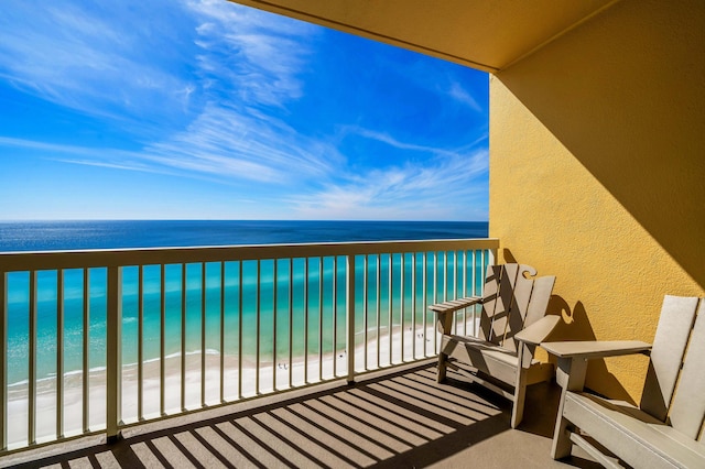 balcony featuring a water view and a beach view