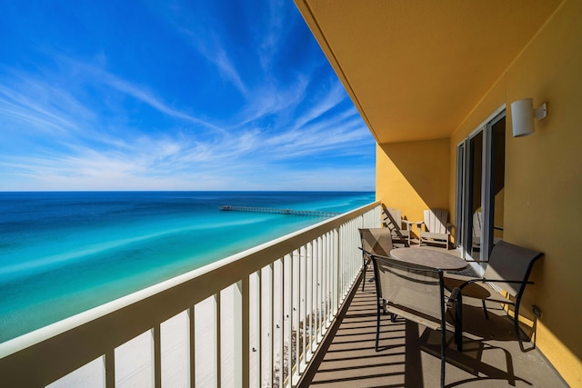 balcony featuring a beach view and a water view