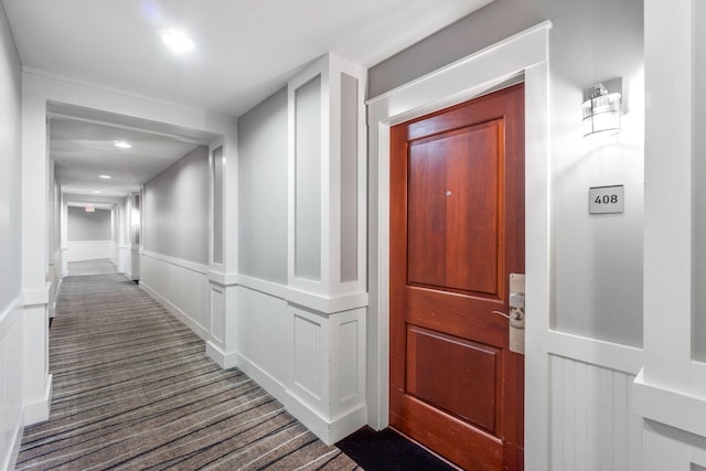 hall with recessed lighting and a decorative wall