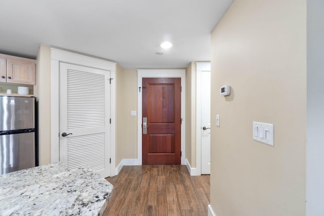 interior space featuring baseboards and dark wood-style flooring