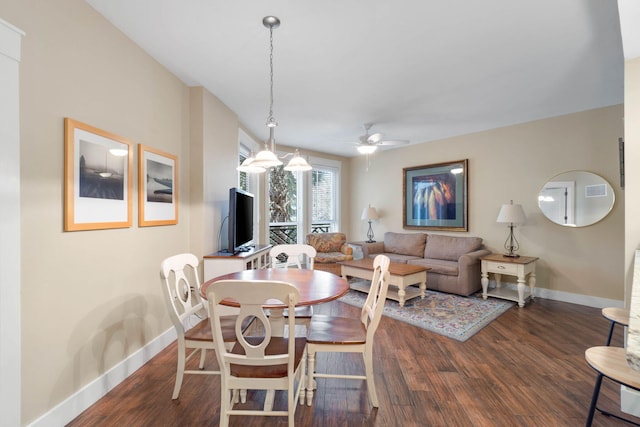 dining area featuring baseboards, a ceiling fan, and dark wood-style flooring