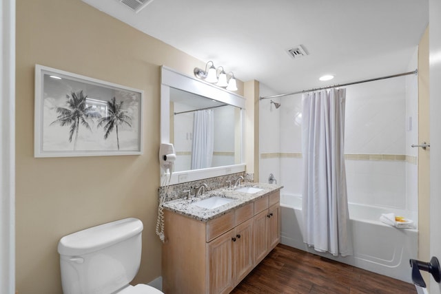 full bathroom with visible vents, shower / bath combination with curtain, wood finished floors, and a sink