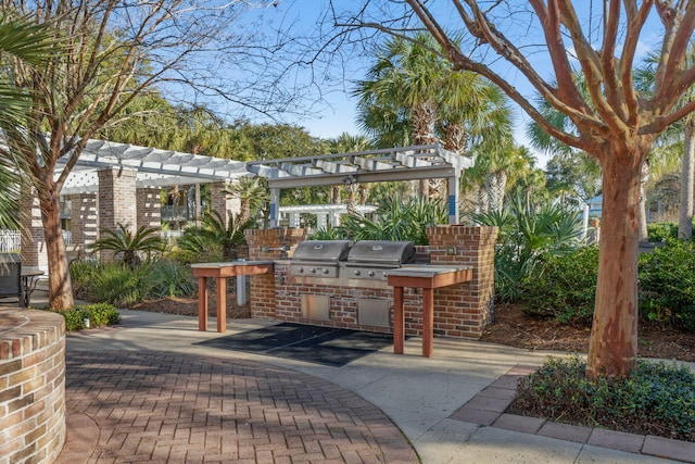 view of patio with exterior kitchen, a pergola, and grilling area