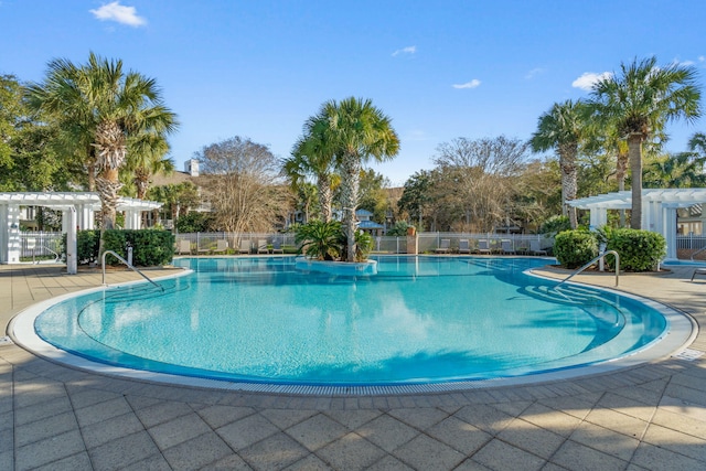 pool with a patio, fence, and a pergola