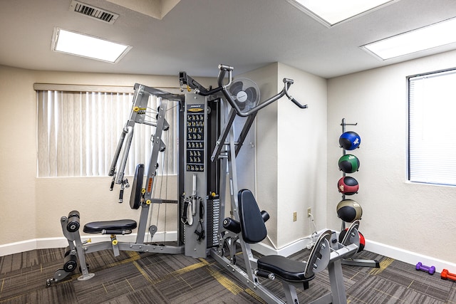 workout room featuring baseboards and visible vents