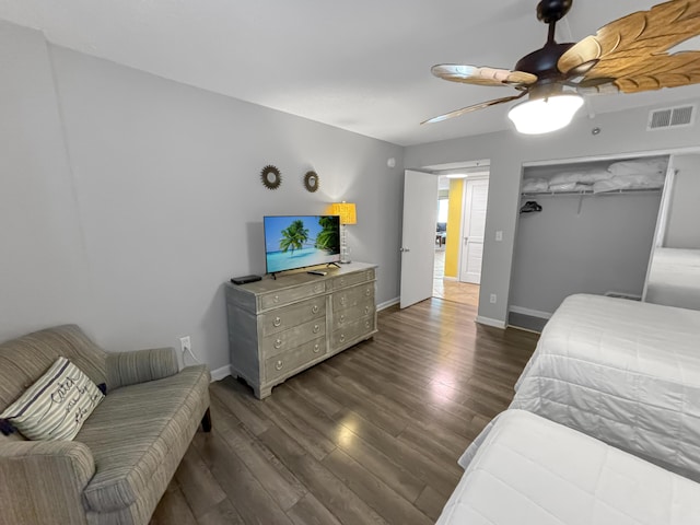 bedroom featuring a ceiling fan, baseboards, visible vents, and wood finished floors