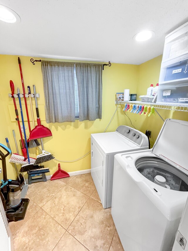 laundry area featuring light tile patterned floors, recessed lighting, laundry area, baseboards, and washing machine and clothes dryer