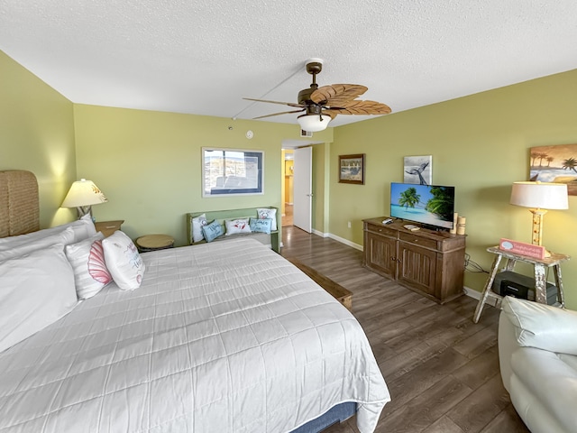 bedroom featuring a textured ceiling, wood finished floors, a ceiling fan, and baseboards