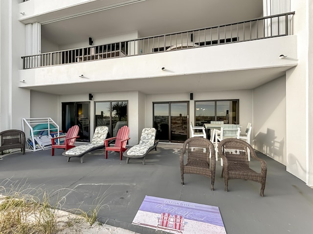 view of patio with a balcony and outdoor dining area