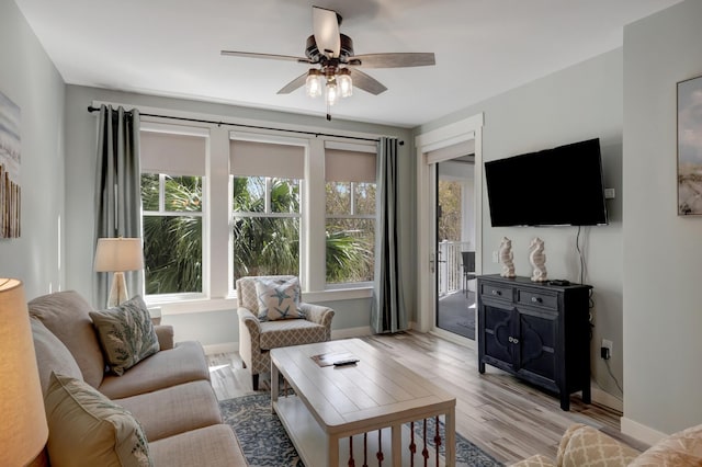 living area with ceiling fan, light wood-type flooring, and baseboards