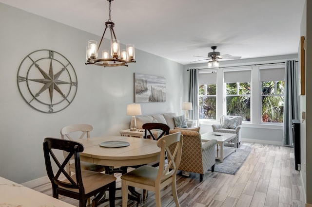 dining room featuring a ceiling fan, baseboards, and light wood finished floors