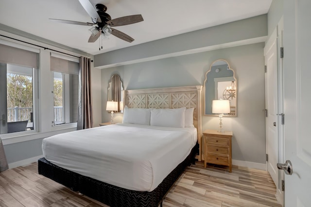 bedroom featuring baseboards, wood finished floors, and a ceiling fan