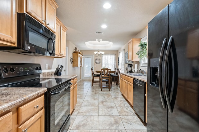 kitchen with a sink, black appliances, a raised ceiling, and light countertops