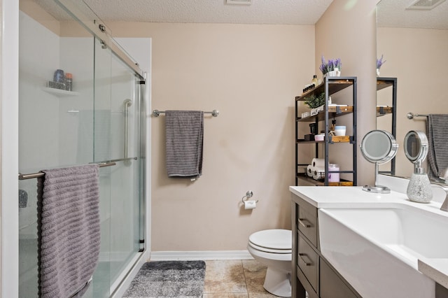 full bathroom with toilet, a stall shower, a textured ceiling, and vanity