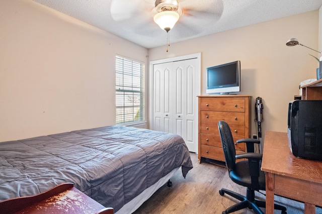 bedroom featuring a closet, ceiling fan, a textured ceiling, and wood finished floors