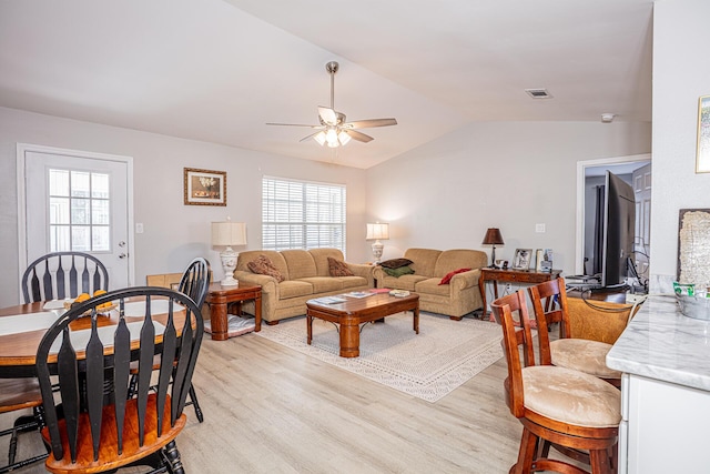 living room featuring light wood-type flooring, visible vents, a healthy amount of sunlight, and a ceiling fan