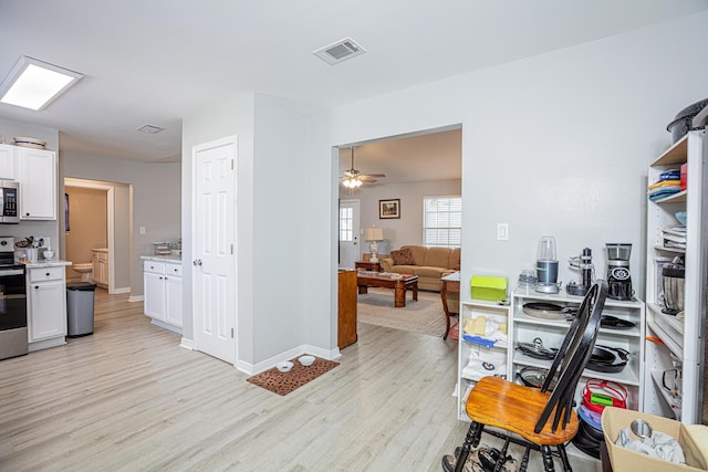 kitchen with visible vents, light wood-style flooring, white cabinets, and stainless steel appliances