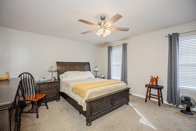 bedroom with a ceiling fan, baseboards, and light carpet