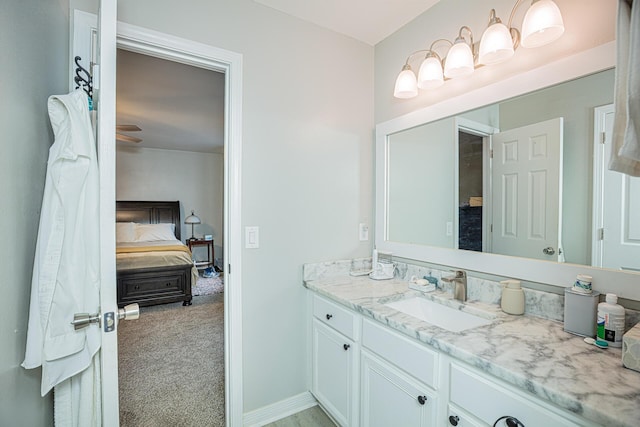 ensuite bathroom with vanity, baseboards, and connected bathroom