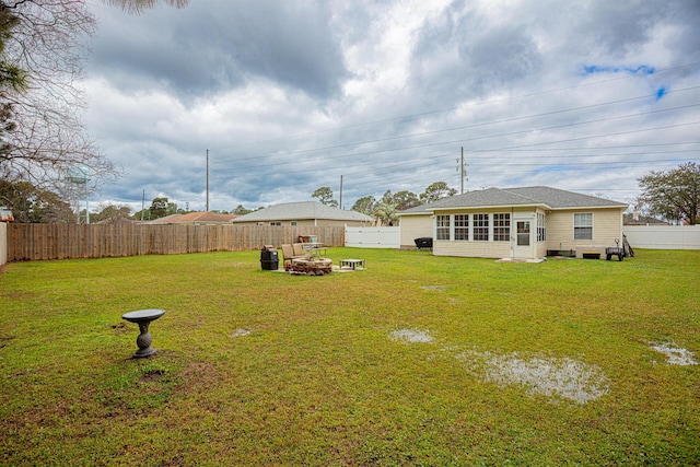 view of yard with an outdoor fire pit and a fenced backyard