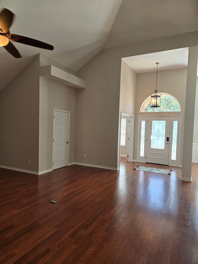 entrance foyer with dark wood-style floors, high vaulted ceiling, ceiling fan, and baseboards