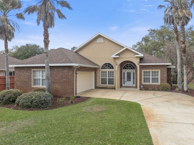 view of front of home featuring a front yard, an attached garage, stucco siding, concrete driveway, and brick siding