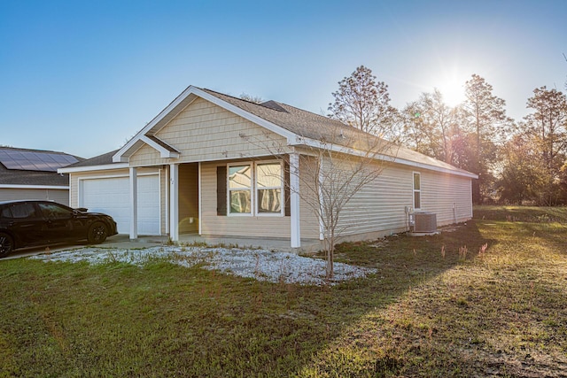 view of front of property with central air condition unit, an attached garage, and a front lawn