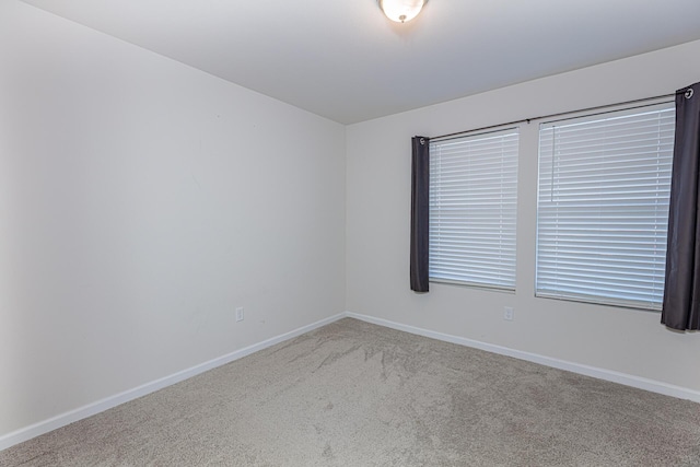 unfurnished room with baseboards and carpet floors