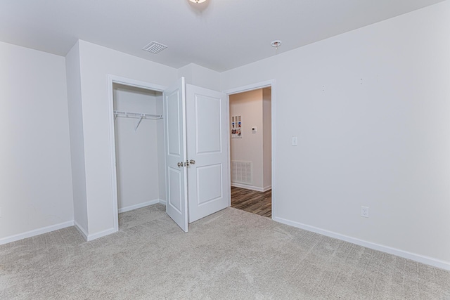unfurnished bedroom featuring carpet floors, a closet, baseboards, and visible vents