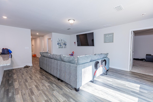 living area with visible vents, baseboards, and wood finished floors